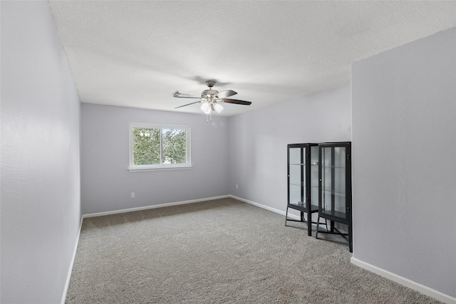 spare room with ceiling fan, a textured ceiling, and carpet flooring