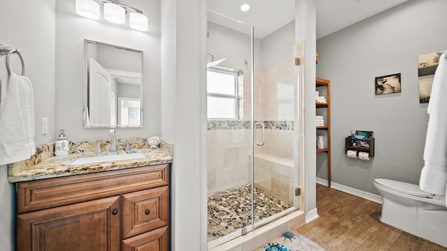 bathroom featuring hardwood / wood-style floors, vanity, toilet, and walk in shower