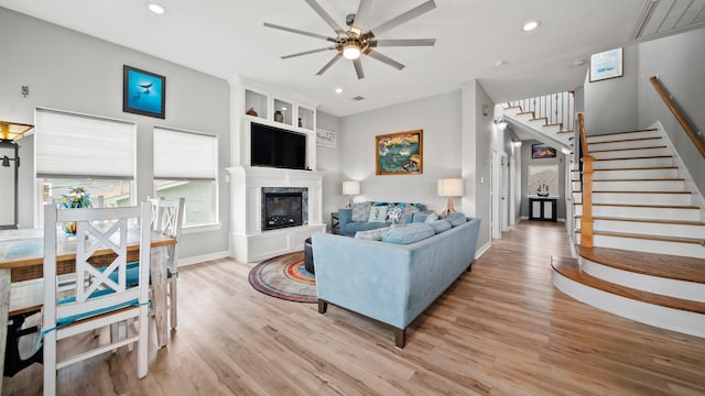 living room featuring ceiling fan, built in features, and light wood-type flooring