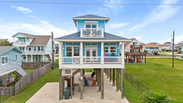 rear view of property with a yard, a balcony, and a patio area