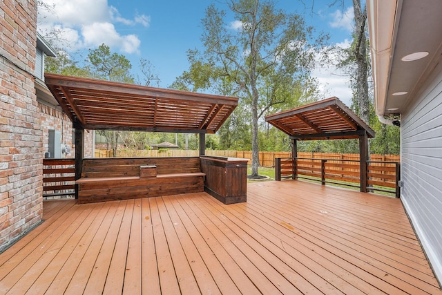 wooden terrace with a pergola and a hot tub