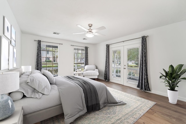 bedroom with ceiling fan, wood-type flooring, access to outside, and french doors