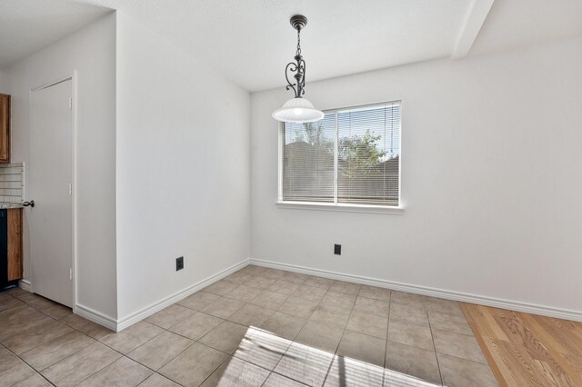 unfurnished dining area with light tile patterned flooring