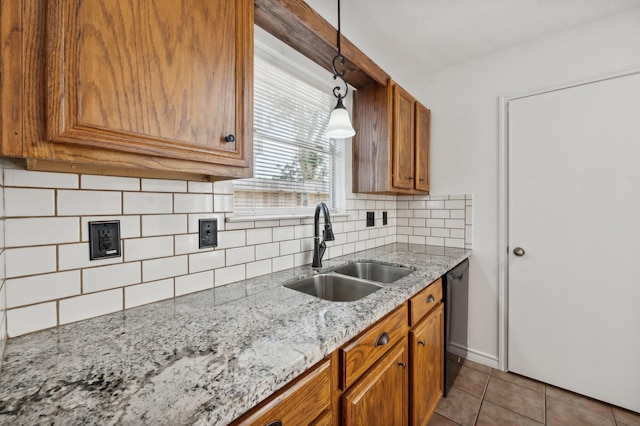 kitchen featuring dishwasher, sink, backsplash, pendant lighting, and light tile patterned floors