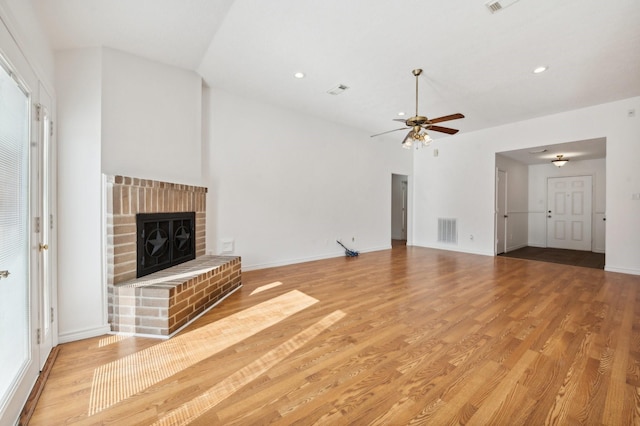 unfurnished living room with a fireplace, light wood-type flooring, and ceiling fan