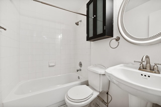 full bathroom with tiled shower / bath combo, toilet, and sink