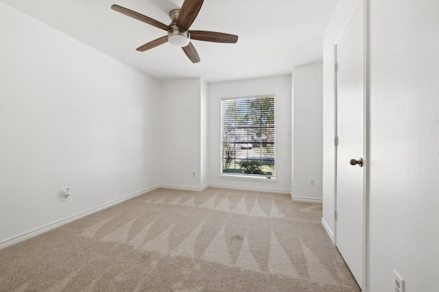 carpeted spare room featuring ceiling fan