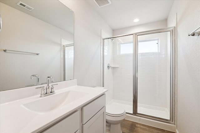 bathroom featuring walk in shower, toilet, vanity, and hardwood / wood-style flooring