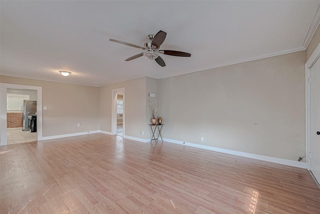 spare room featuring light wood-type flooring, ceiling fan, and crown molding