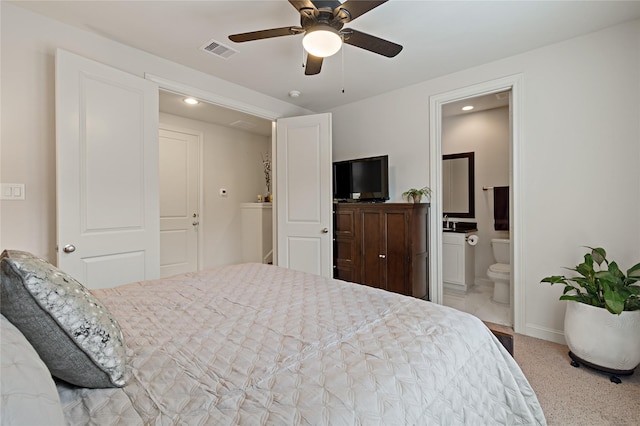 carpeted bedroom featuring ceiling fan and ensuite bath