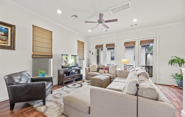 living room featuring ceiling fan, dark hardwood / wood-style flooring, and crown molding