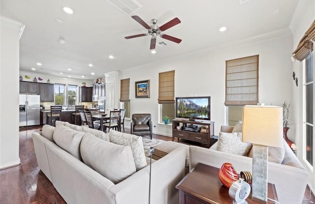 living room with dark hardwood / wood-style flooring, ceiling fan, and crown molding