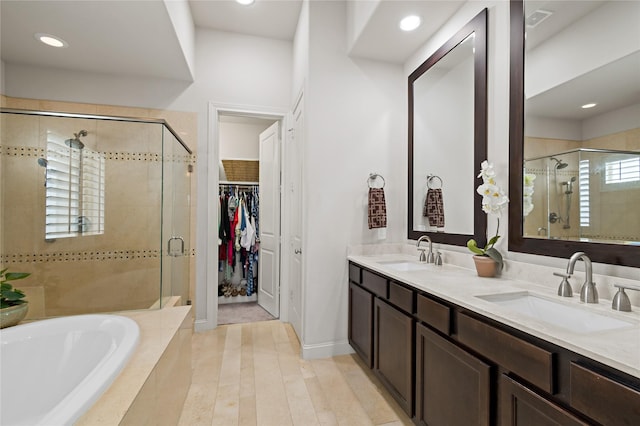 bathroom with vanity and shower with separate bathtub