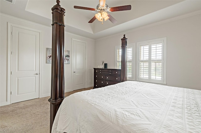 carpeted bedroom with a closet, a tray ceiling, and ceiling fan