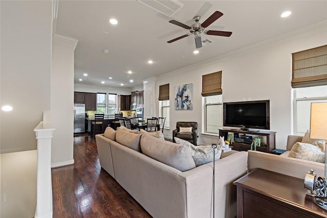 living room with crown molding, dark hardwood / wood-style flooring, and ceiling fan