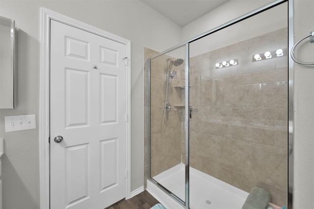 bathroom with hardwood / wood-style floors and a shower with door