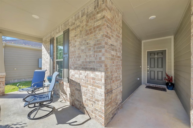 view of exterior entry featuring covered porch