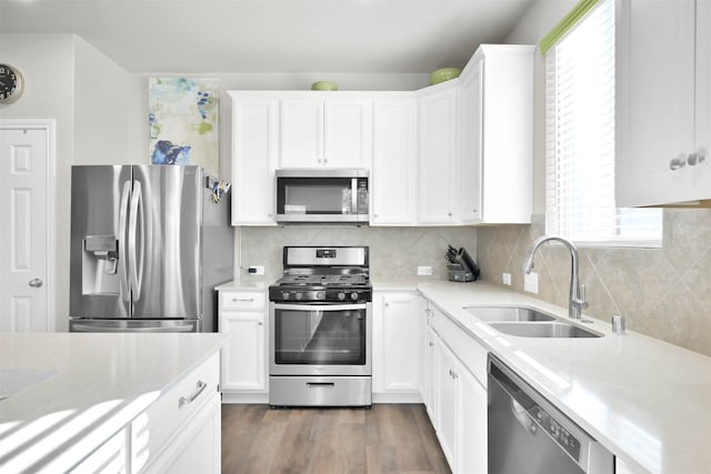 kitchen with white cabinetry, sink, tasteful backsplash, dark hardwood / wood-style flooring, and appliances with stainless steel finishes