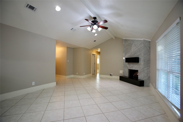 unfurnished living room featuring ceiling fan, a fireplace, light tile patterned floors, and lofted ceiling with beams