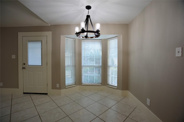 unfurnished dining area with light tile patterned floors and a notable chandelier