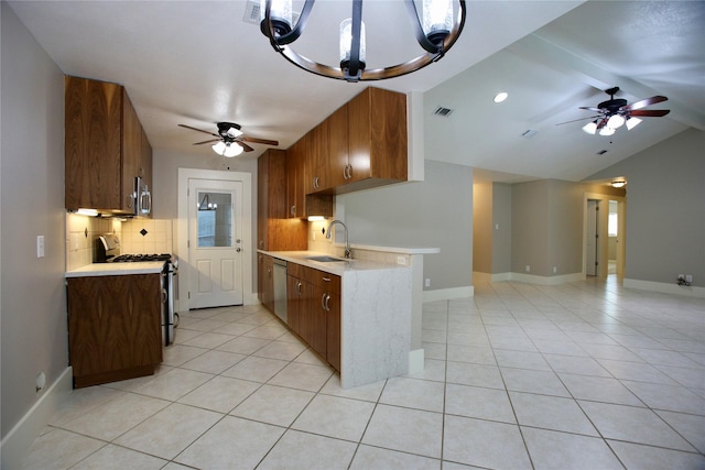 kitchen with backsplash, sink, ceiling fan with notable chandelier, and appliances with stainless steel finishes