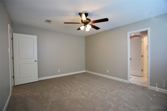 empty room featuring ceiling fan and light carpet