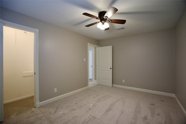 unfurnished bedroom with light colored carpet and ceiling fan