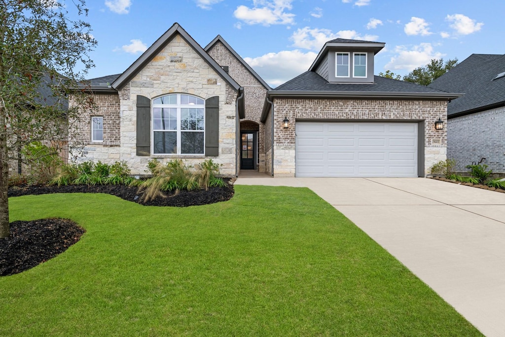 view of front of property with a garage and a front yard