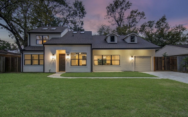 view of front of house featuring a garage and a lawn