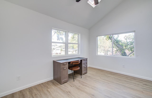 home office featuring light wood-type flooring, high vaulted ceiling, and a skylight