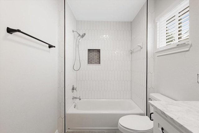 full bathroom featuring tiled shower / bath, vanity, and toilet