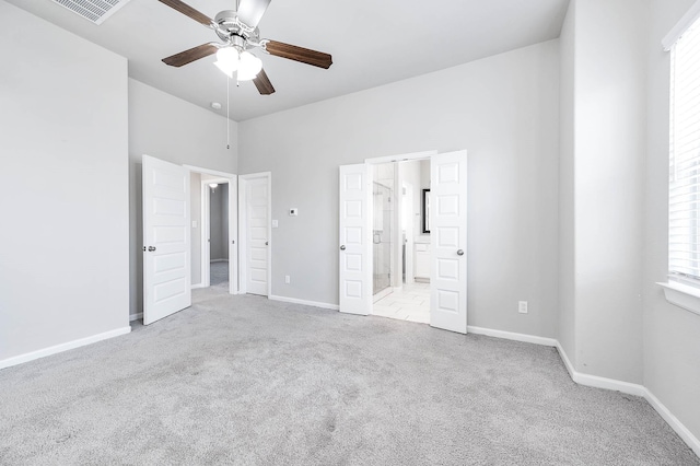 unfurnished bedroom featuring connected bathroom, ceiling fan, and light colored carpet