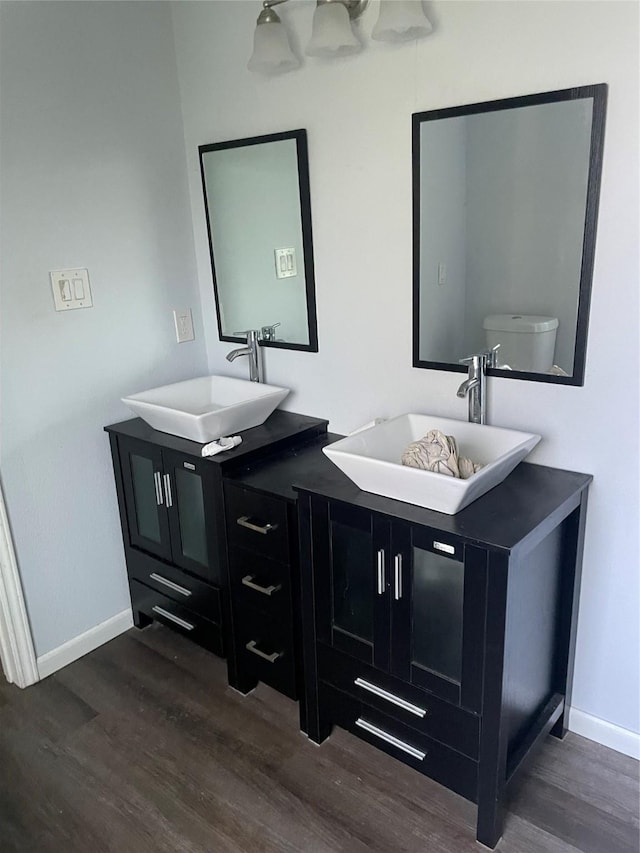 bathroom with hardwood / wood-style flooring, vanity, and toilet