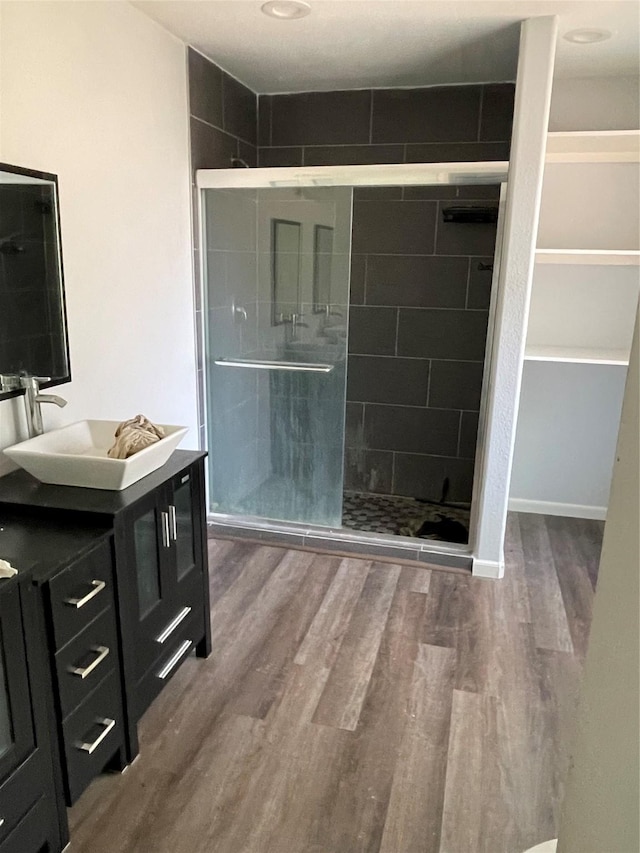 bathroom featuring hardwood / wood-style floors, vanity, and walk in shower