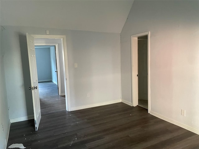 unfurnished room featuring dark hardwood / wood-style floors and lofted ceiling