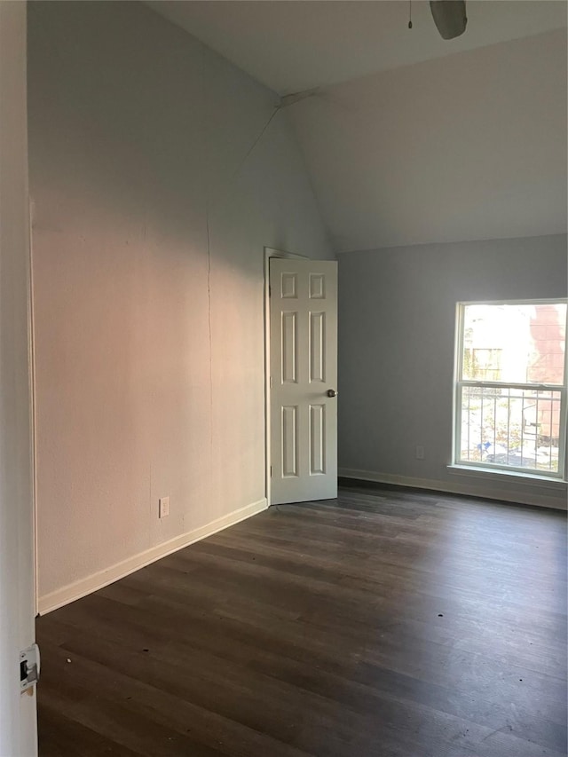 empty room featuring dark hardwood / wood-style floors, vaulted ceiling, and ceiling fan