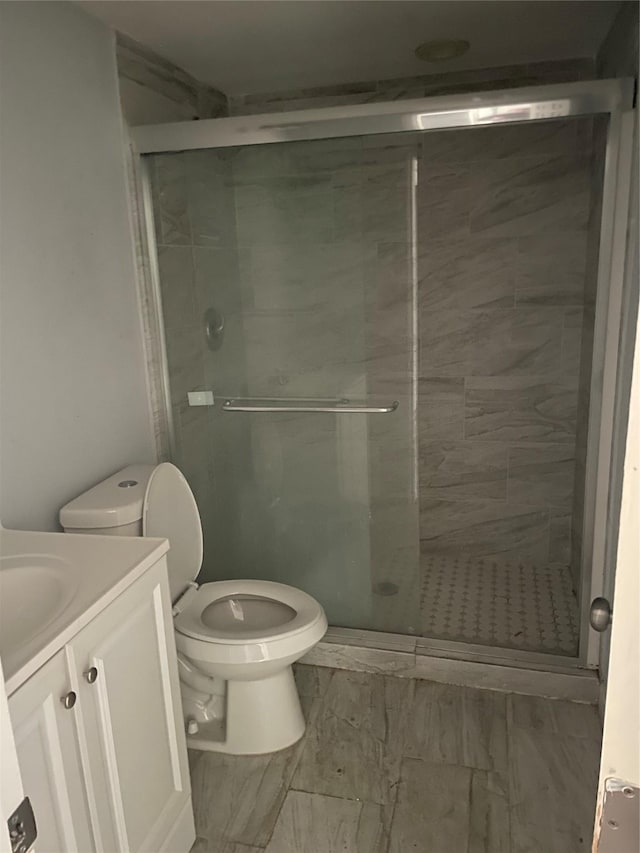 bathroom with toilet, vanity, and walk in shower