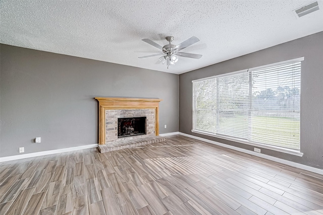 unfurnished living room featuring ceiling fan, a textured ceiling, and light hardwood / wood-style flooring