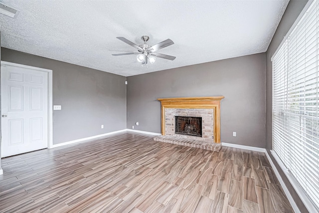 unfurnished living room with a textured ceiling, light hardwood / wood-style flooring, and ceiling fan