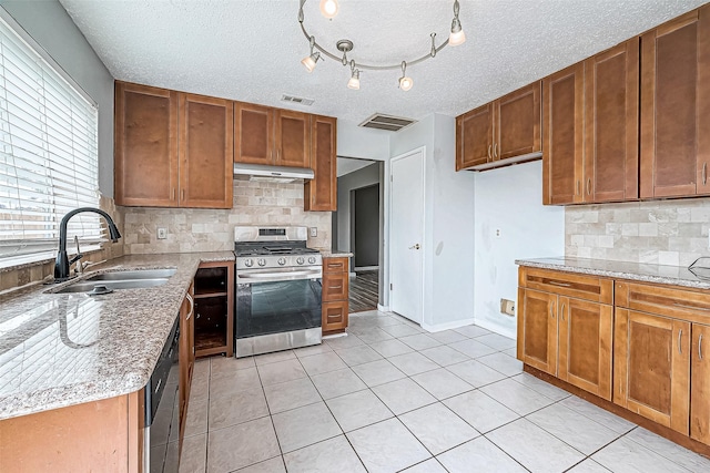 kitchen with appliances with stainless steel finishes, a textured ceiling, tasteful backsplash, and sink