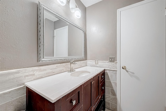 bathroom featuring vanity and tile walls