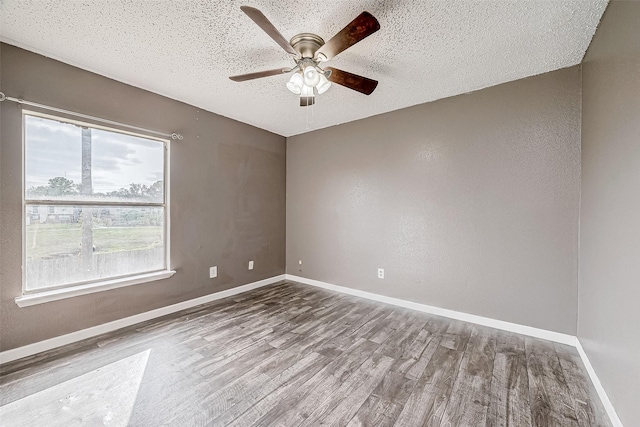 spare room featuring ceiling fan, wood-type flooring, and a textured ceiling