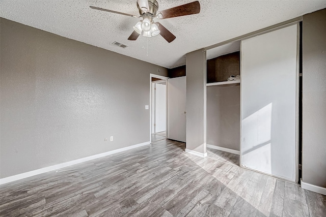 unfurnished bedroom with ceiling fan, a textured ceiling, and light hardwood / wood-style flooring