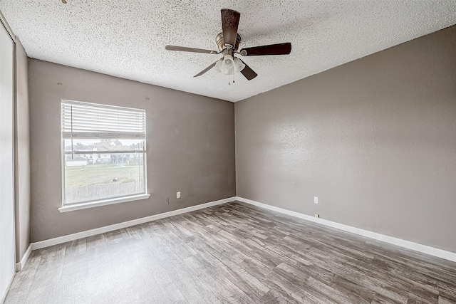 spare room with ceiling fan, wood-type flooring, and a textured ceiling