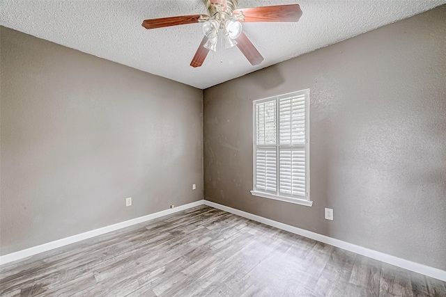 spare room featuring ceiling fan, light hardwood / wood-style floors, and a textured ceiling