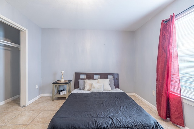 tiled bedroom with multiple windows and a closet