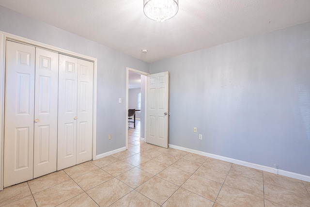 unfurnished bedroom featuring light tile patterned floors, a closet, and a textured ceiling