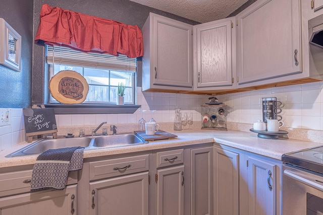 kitchen featuring sink, backsplash, and a textured ceiling