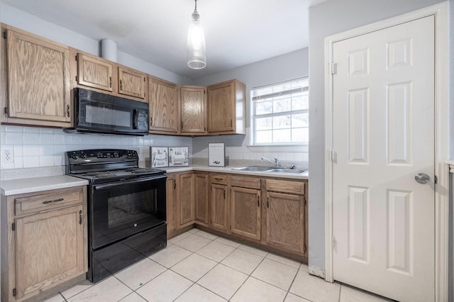 kitchen with hanging light fixtures, black appliances, decorative backsplash, light tile patterned floors, and sink