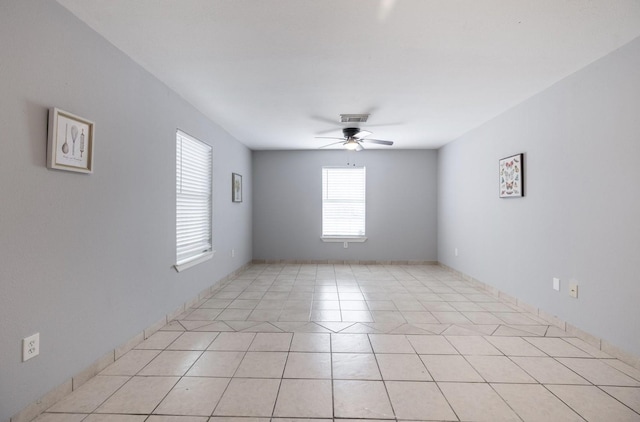 tiled spare room featuring ceiling fan